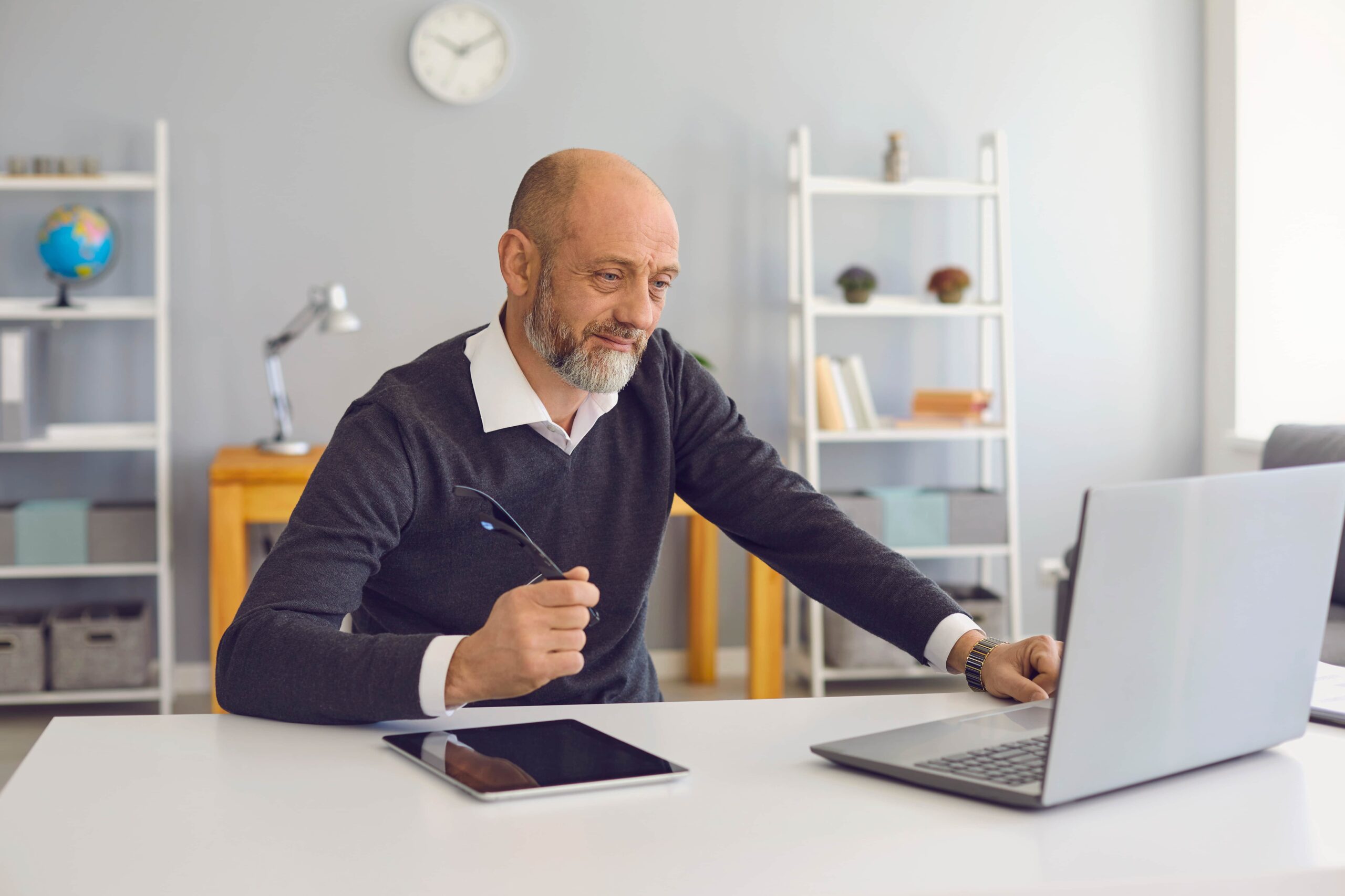 Bearded man sitting in front of laptop researching Medicare