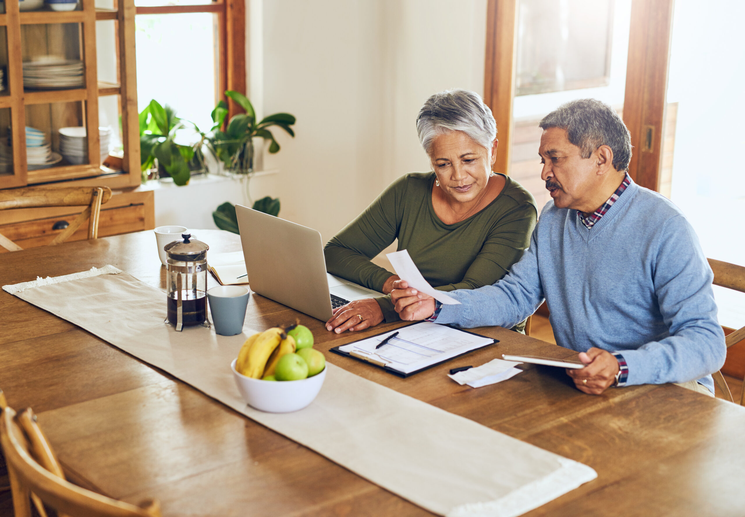 Finance, laptop and older couple with bills, paperwork and receipt documents for life insurance finding ways to save money on their fixed income.