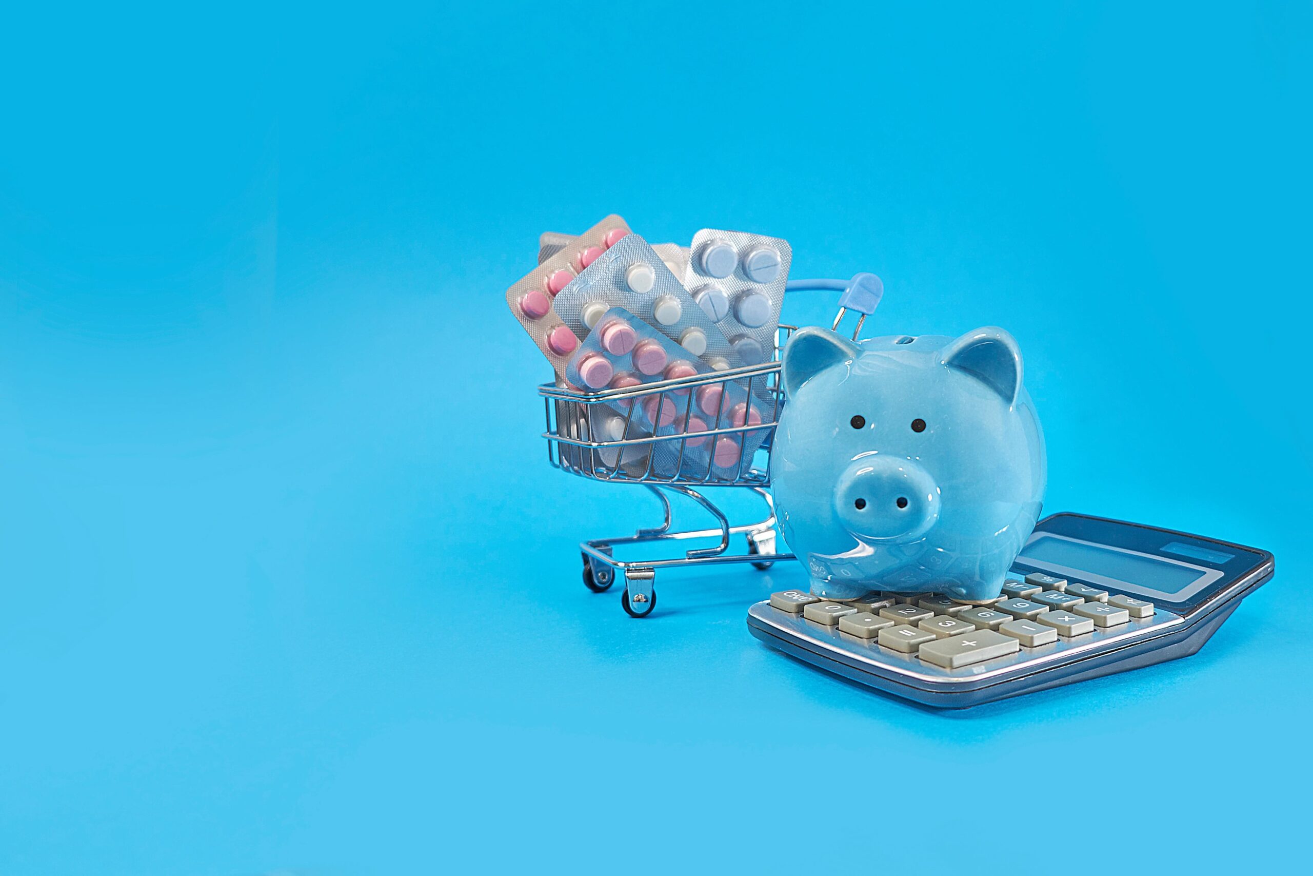 piggy bank and basket with pills on a blue background, concept of how to save on prescription drug costs