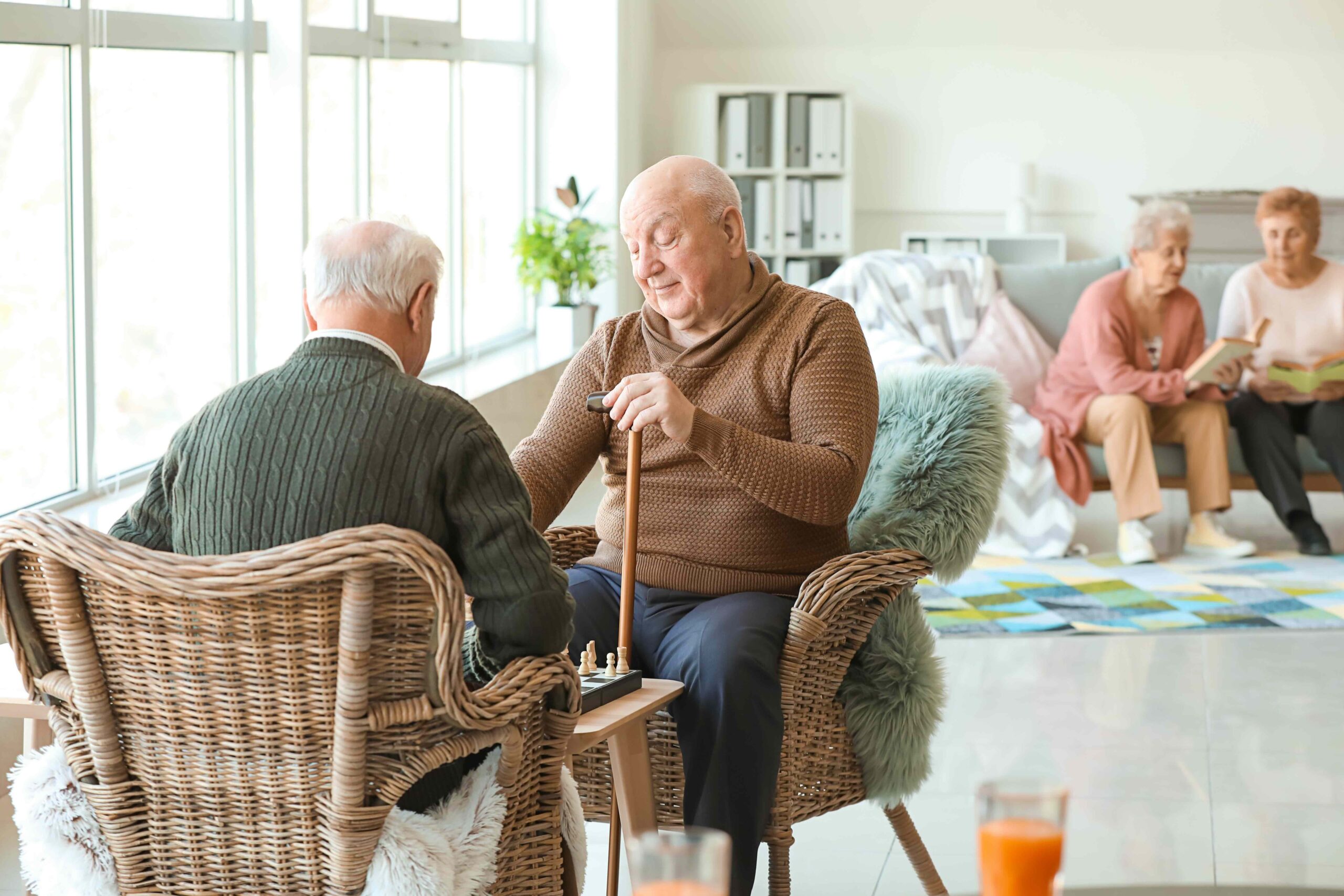 Senior men playing chess, activities for assisted living residents like these sharpen the mind and help stay connected.