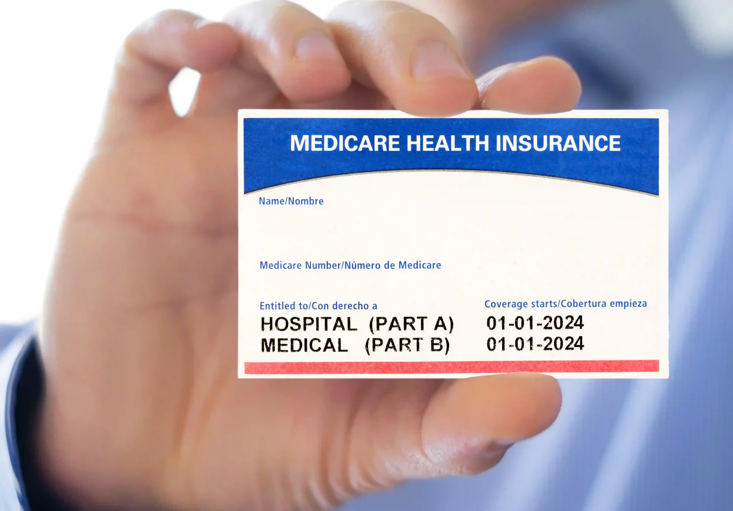 A hand holding a blank red, white and blue Medicare card