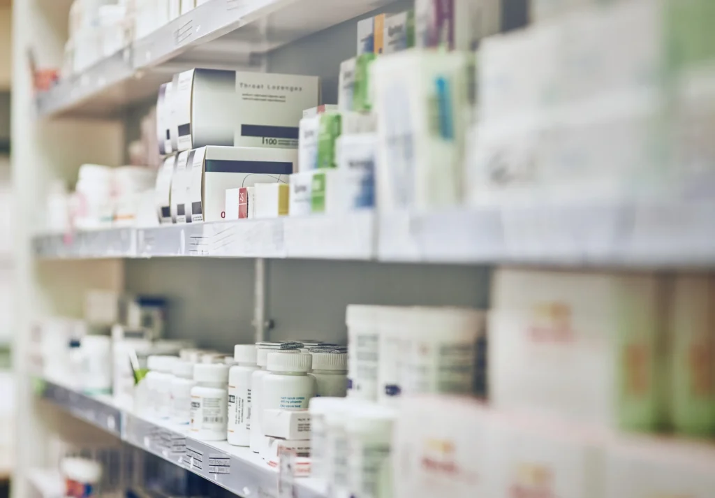 A medium close up of a pharmacy shelf with boxes of prescriptions