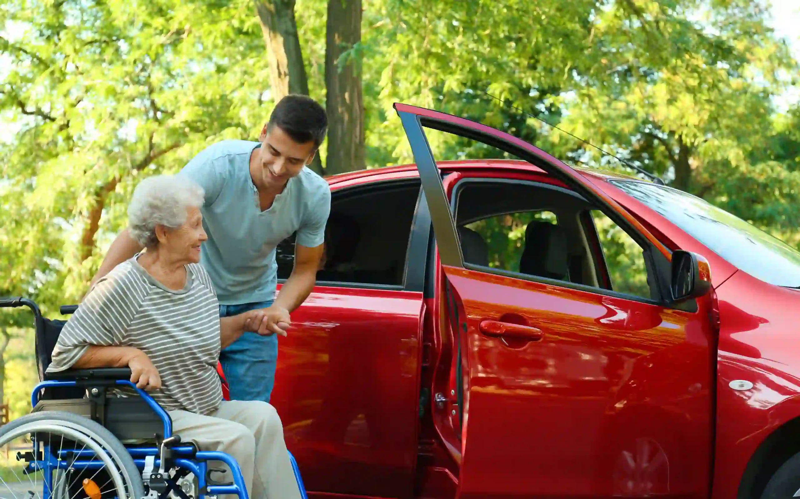 A senior woman is helped by a caregiver into a vehicle for transportation to a medical appointment
