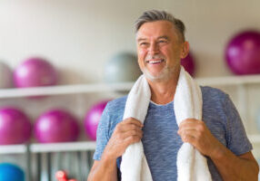 healthy man smiling in gym after senior fitness test